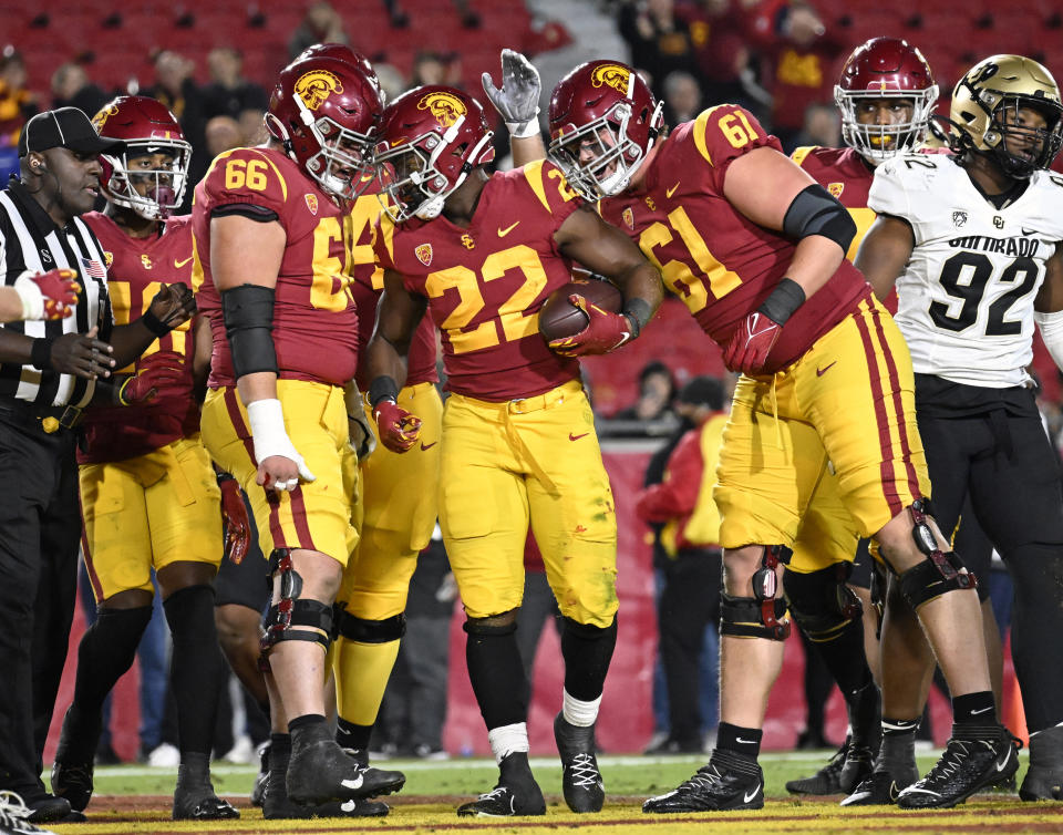 Southern California running back Darwin Barlow (22) is congratulated by offensive linemen Gino Quinones (66) and Joe Bryson (61) after scoring a touchdown in the fourth quarter of an NCAA college football game against Colorado, Friday, Nov. 11, 2022, in Los Angeles. (AP Photo/John McCoy)