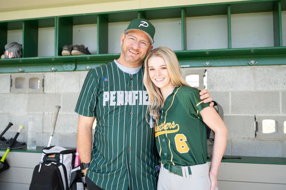 Pennfield varsity baseball coach Rob Moran poses with his daughter Avery Moran, a junior on the Pennfield varsity softball team, in the dugout at Pennfield High School on Wednesday, Apr. 26, 2023.