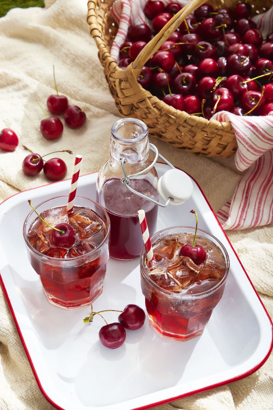 cherry syrup and rum soda in glasses with ice and fresh cherries for garnish