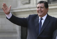 FILE - In this June 17, 2011 file photo, Peru's outgoing President Alan Garcia waves to the press during a meeting with Peru's President-elect Ollanta Humala at the government palace in Lima, Peru. Peru’s government said in a Nov. 18, 2018 statement that the former president is seeking asylum in Uruguay days after a prosecutor sought to retain his passport as part of a corruption probe. (AP Photo/Marcelo Luna, File)