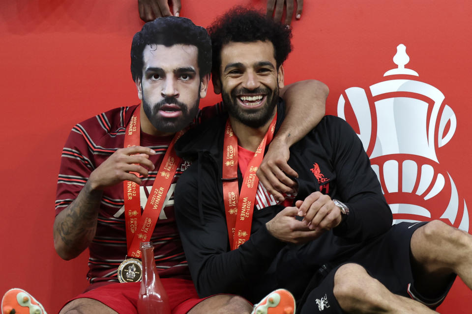 Liverpool's Thiago, wearing a mask of Mohamed Salah, embraces Salah after they won the English FA Cup final soccer match between Chelsea and Liverpool, at Wembley stadium, in London, Saturday, May 14, 2022. Liverpool won 6-5 on penalties after the game ended in a goalless draw. (AP Photo/Ian Walton)