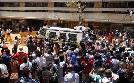 Bystanders watch as a police van takes Olympic and Paralympic track star Oscar Pistorius to prison after his sentencing in Pretoria October 21, 2014. REUTERS/Mike Hutchings