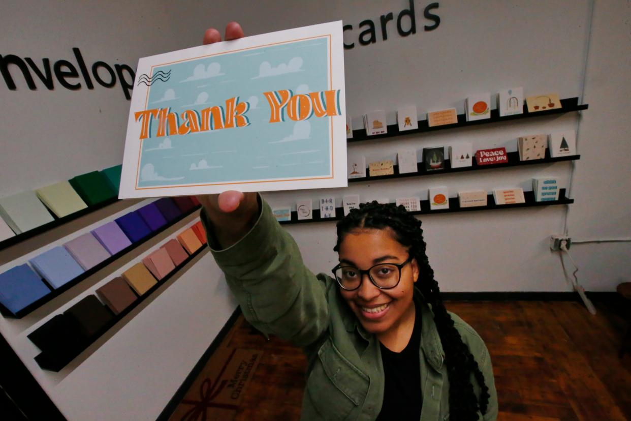 Jaden Reyes holds up one of the custom cards she designed at her newly opened Brown Suga Stationery & Print Shop in the Kilburn Mill in New Bedford.