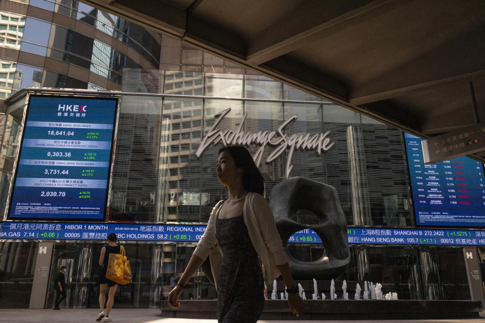 A pedestrian passes by the Hong Kong Stock Exchange electronic screen in Hong Kong, Friday, June 2, 2023. Asian stock markets followed Wall Street higher on Friday ahead of an update on the U.S. jobs market after Federal Reserve officials indicated they might skip another interest rate hike this month. (AP Photo/Louise Delmotte)