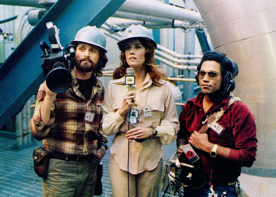 Jane Fonda stands with a mic between Michael Douglas and Daniel Valdez, her crew