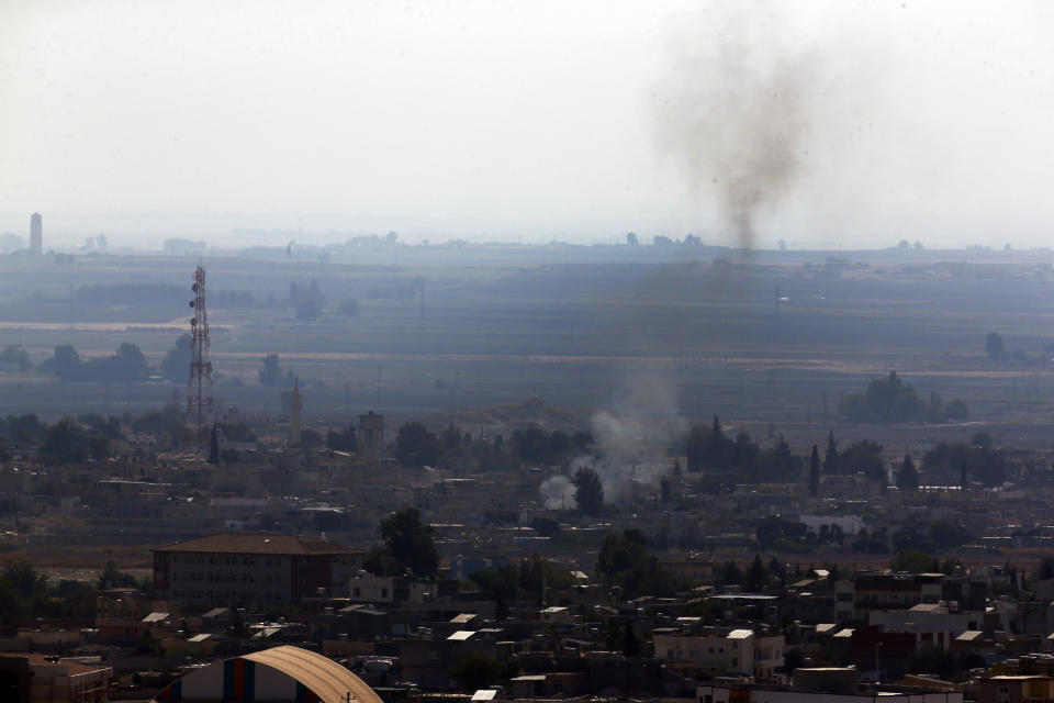 In this photo taken from the Turkish side of the border between Turkey and Syria, in Ceylanpinar, Sanliurfa province, southeastern Turkey, smoke billows from targets in Ras al-Ayn, Syria, caused by shelling by Turkish forces, Friday, Oct. 18, 2019. Fighting continued in a northeast Syrian border town at the center of the fight between Turkey and Kurdish forces early Friday, despite a U.S.-brokered cease-fire that went into effect overnight. Shelling and gunfire could be heard in and around Ras al-Ayn, as smoke billowed from locations near the border with Turkey and the Turkish town of Ceylanpinar. (AP Photo/Lefteris Pitarakis)