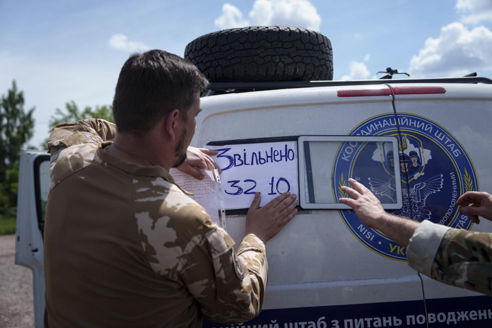 Ukrainian servicemen change a plate showing the total sum of 3210 of POWs and civilians returned home in Sumy region, Ukraine, Friday, May 31, 2024. Ukraine returned 75 prisoners, including four civilians, in the latest exchange of POWs with Russia. It's the fourth prisoner swap this year, and 52nd since Russia invaded Ukraine. In all, 3 210 Ukrainian servicemen and civilians were returned since the outbreak of the war. (AP Photo/Evgeniy Maloletka)