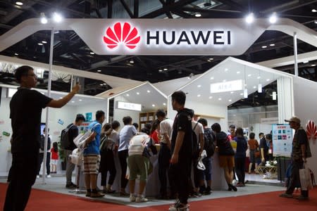 People look at products at the Huawei stall at the International Consumer Electronics Expo in Beijing