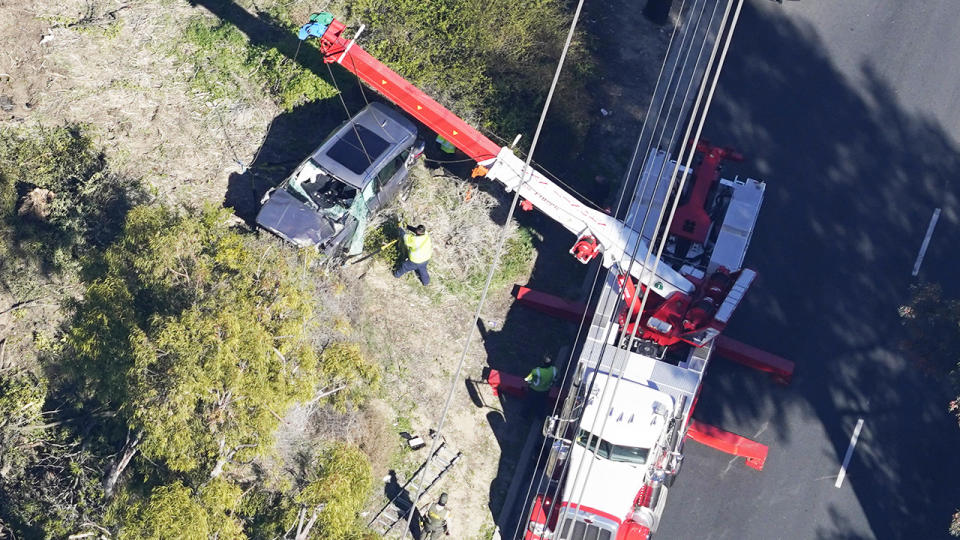 Workers, pictured here moving Tiger Woods' vehicle after his shocking crash.