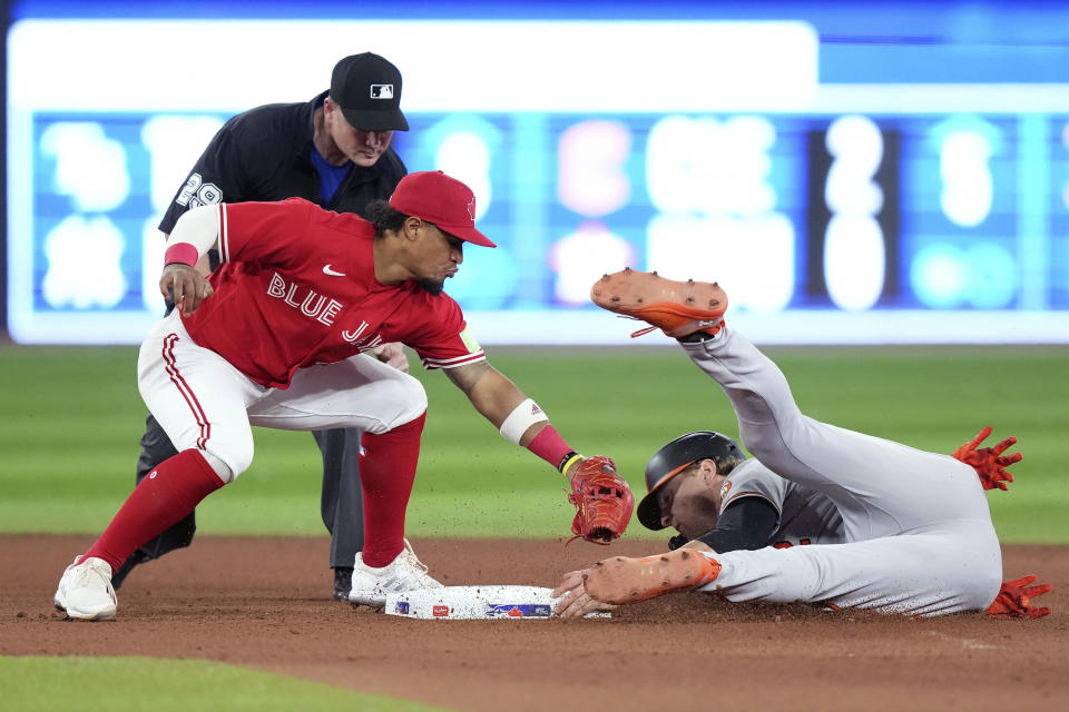 Baltimore Orioles' Gunnar Henderson, right, is safe at second base after Toronto Blue Jays' Santiago Espinal, front left missed the tag during seventh-inning baseball game action in Toronto, Monday, July 31, 2023. (Nathan Denette/The Canadian Press via AP)