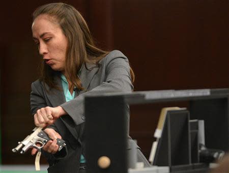 Florida Department of Law Enforcement firearms analyst Marie Pagan shows a 9mm pistol allegedly used in an altercation which prosecutors say resulted in the shooting death of unarmed teen Jordan Davis, in the murder trial of Michael Dunn during testimony in Duval County Courthouse in Jacksonville, Florida on February 10, 2014. REUTERS/Bob Mack/Pool