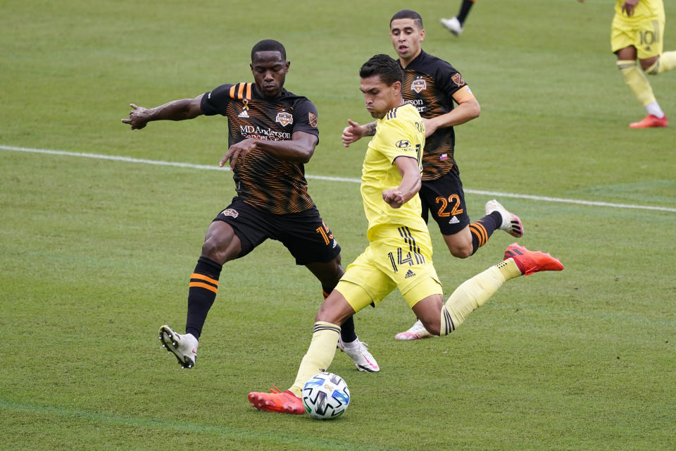 Nashville forward Daniel Rios (14) takes a shot ahead of Houston Dynamo defender Maynor Figueroa (15) and midfielder Matias Vera (22) during the first half of an MLS soccer match Saturday, Sept. 26, 2020, in Nashville, Tenn. (AP Photo/Mark Humphrey)