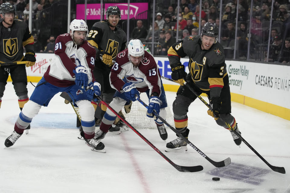 From left, Colorado Avalanche center Nazem Kadri (91) right wing Valeri Nichushkin (13) and Vegas Golden Knights defenseman Brayden McNabb (3) battle for the puck during the first period of an NHL hockey game Saturday, Feb. 26, 2022, in Las Vegas. (AP Photo/John Locher)