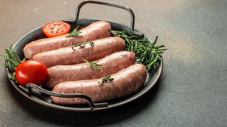 uncooked sausages on pan