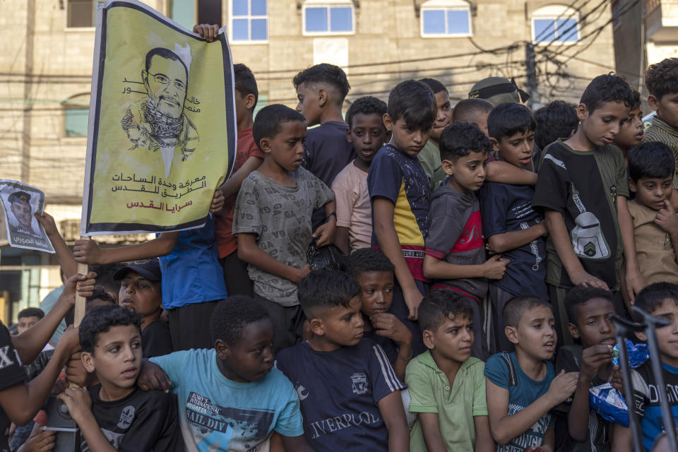 Children hold a photo of Islamic Jihad commander Khaled Mansour, who was killed in an Israeli airstrike, as Palestinian Islamic Jihad fighters take part in an anti-Israel rally in Rafah, south of Gaza City, Wednesday, Aug. 24, 2022. (AP Photo/Fatima Shbair)