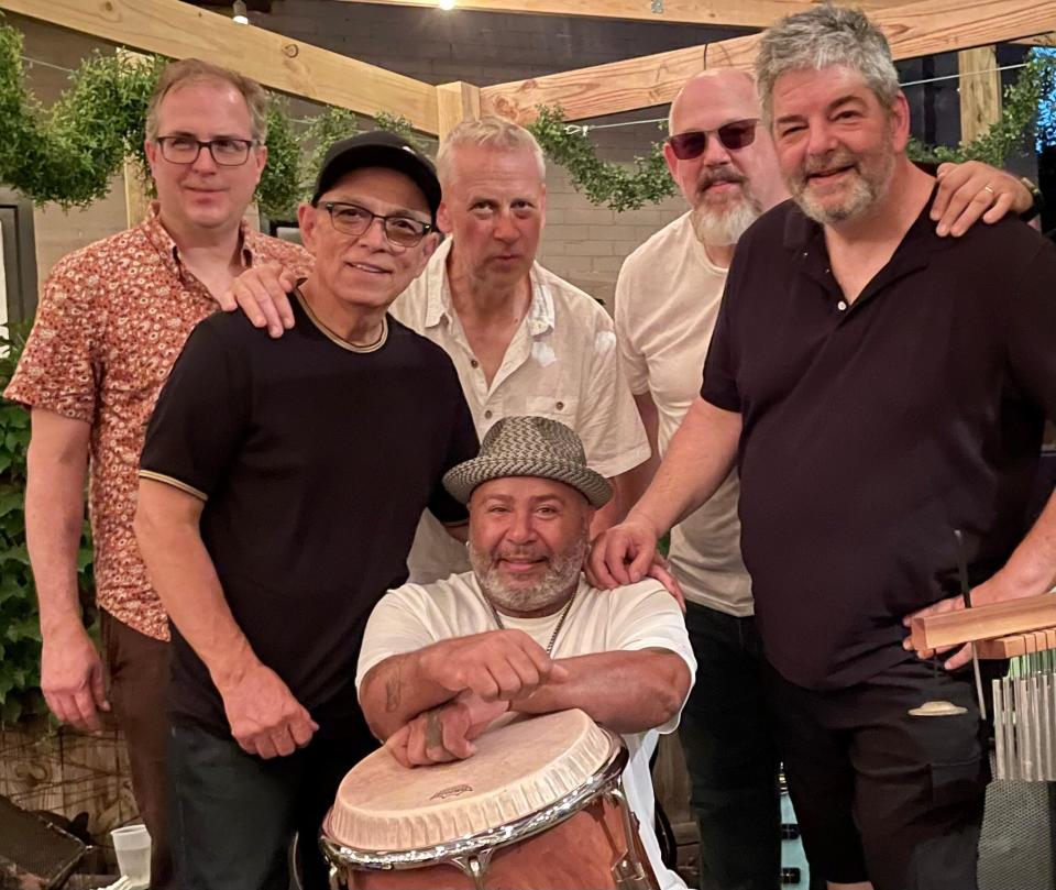 Toty Ramos (second from left) poses with members of the Toty Ramos Sextet. Pictured standing from left are saxophonist Geof Bradfield, Ramos, trumpet player Russ Johnson, bassist John Wheeler, and drummer Dave Bayles. Seated is congas player Ulisis Santiago.