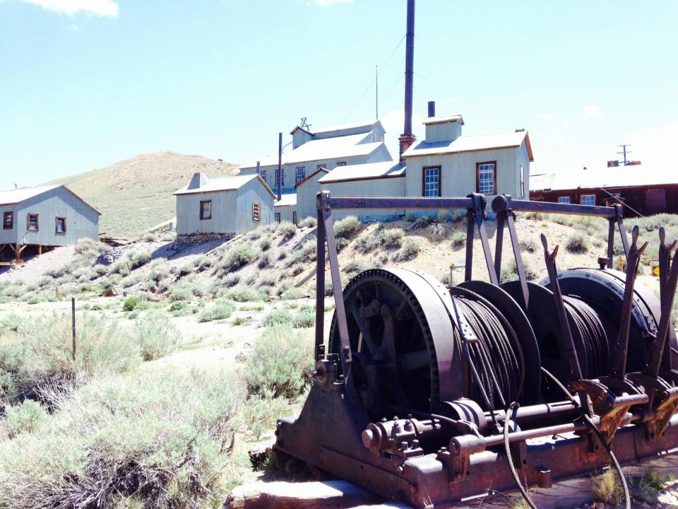 Old mining winch stands in front of the Standard Mine and Mill on Bodie Bluff.