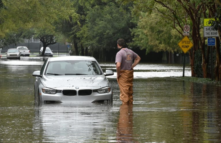 A man looks at his stranded car on a flooded street in downtown Charleston, South Carolina on October 4, 2015