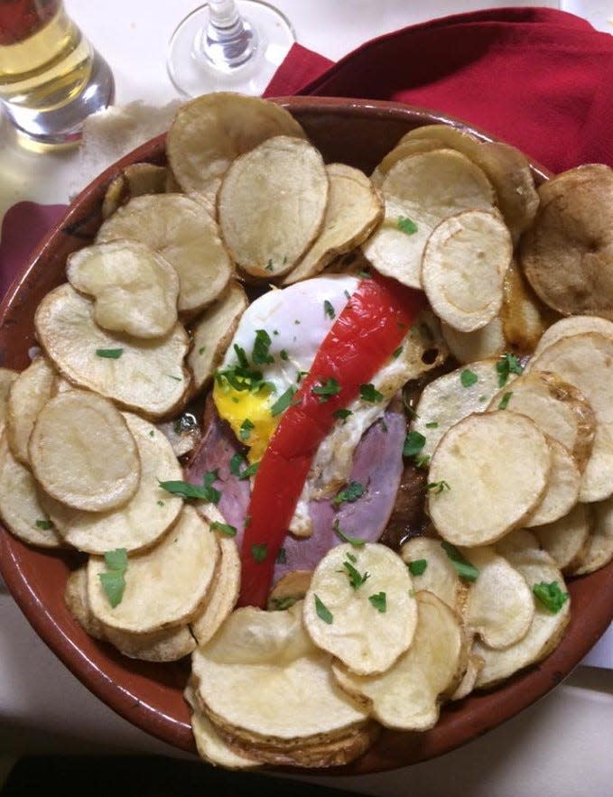 The bife à Portuguesa at Taunton Sports Club Restaurant is topped with an egg, ham, and red pepper, and served with rounded fries.