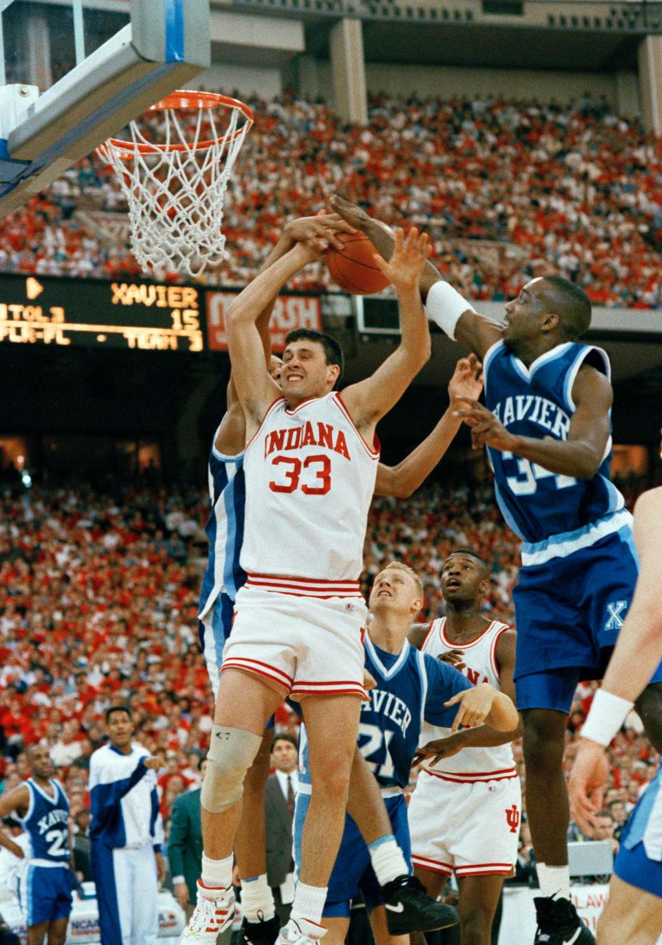 Indiana's Pat Graham (33) has the ball knocked away by Xavier's Brian Grant, background, and Tyrice Walker (34) during first half NCAA Midwest Regional action at the Hoosier Dome, March 21, 1993, Indianapolis.