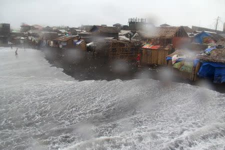 Residents are seen in a coastal area battered by strong winds and heavy rains brought by typhoon Melor in Legazpi city, central Philippines December 15, 2015. REUTERS/Rhadyz Barcia