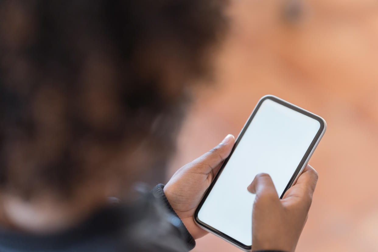 African American boy holding and touching blank screen template smart phone in the car. Smart phone screen is empty with clipping path.