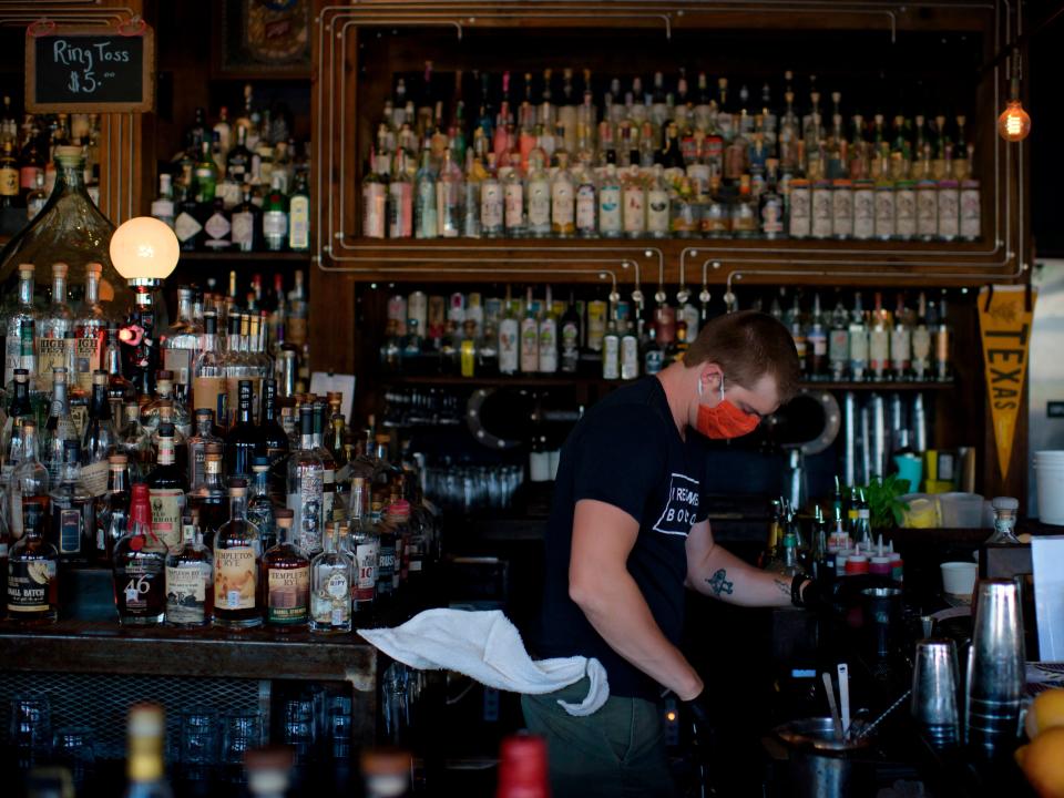 A bartender wearing a facemask and gloves makes drinks at Eight Row Flint in Houston, Texas, on May 22, 2020, amid the novel coronavirus pandemic.