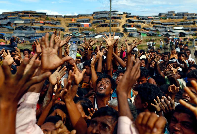 FILE PHOTO: Rohingya refugees stretch their hands to receive aid distributed by local organisations at Balukhali makeshift refugee camp in Cox's Bazar