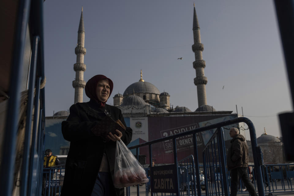 In this Sunday, Feb. 17, 2019 photo, a shopper walks away after buying groceries at a government-run market selling spinach, tomatoes and peppers at discounted prices in an Istanbul neighbourhood. Turkey's President Recep Tayyip Erdogan's government has set up dozens of these temporary stalls in Turkey's largest cities in a bid to mitigate the effects of soaring food prices that have stung households. (AP Photo/Emrah Gurel)