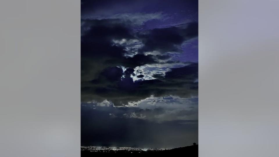 <div>Hiding behind the clouds, the moon glows over the White Tank Mountains. Thanks Lyndsay Quilter for submitting this photo!</div>