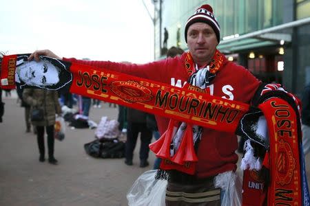 A street seller holds a Jose Mourinho themed Manchester United scarf at Old Trafford, Manchester Britain, December 28, 2015. REUTERS/Jason Cairnduff