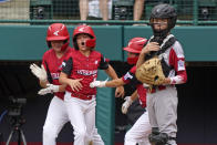 Hamilton, Ohio's JJ Vogel, left, Gage Maggard, left center, and Hamilton, Ohio's Krew Brown, right center, celebrate behind Sioux Falls, S.D. catcher Easton Riley after scoring during the second inning of a baseball game at the Little League World Series in South Williamsport, Pa., Saturday, Aug. 28, 2021. (AP Photo/Gene J. Puskar)