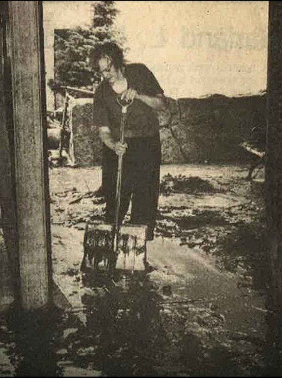 Park Theatre co-owner Olga Stranger shovels mud from the theatre's lobby in Estes Park, Colo., on July 15, 1982, after the Lawn Lake dam breached above the town.