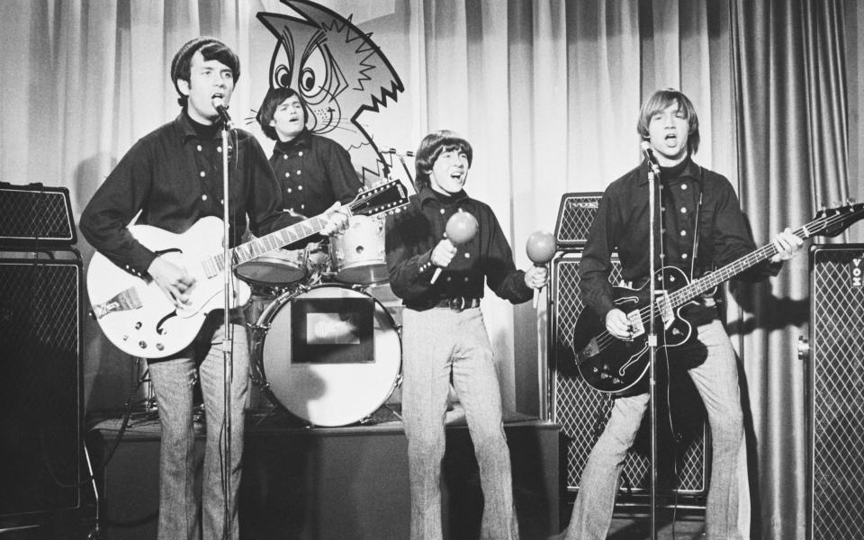 A black and white photo shows the band performing on stage - NBC