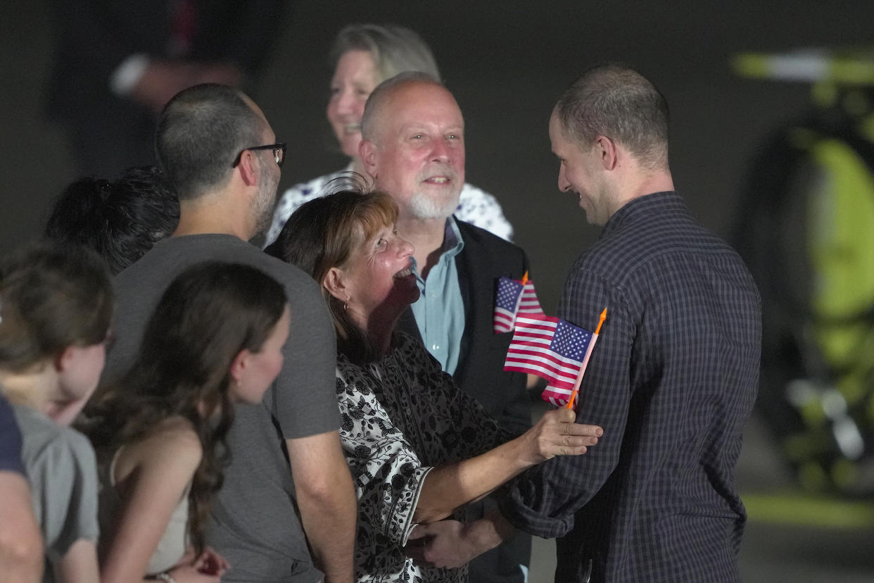 Reporter Evan Gershkovich is greeted by his parents, Mikhail Gershkovich, and Ella Milman, and other family members on the tarmac at Andrews Air Force Base.