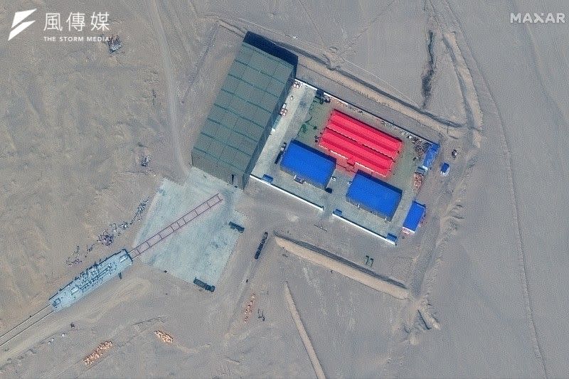 <cite>2021年11月，人造衛星揭露中國人民解放軍在新疆沙漠設置模擬美軍航母的「靶艦」（AP）</cite>