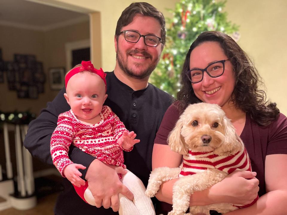 a family takes a photo in front of a Christmas tree