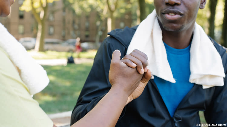 Two black men clasping hands