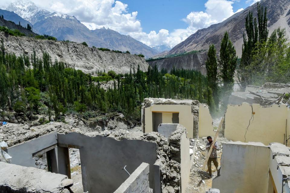 A resident clears debris from a damaged house after a lake outburst because of a melting glacier in Hassanabad village of Pakistan’s Gilgit-Baltistan region in June this year (Getty Images)