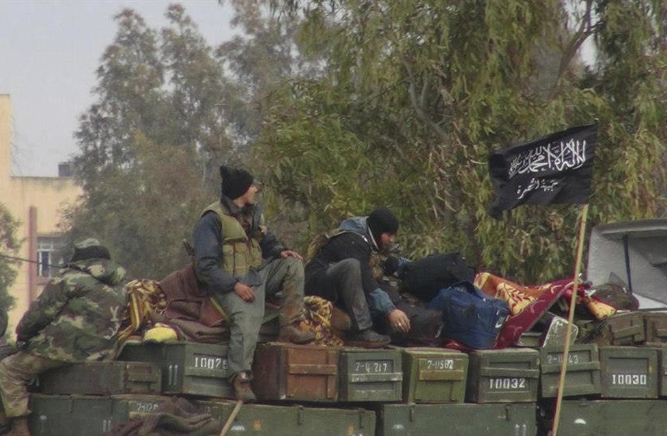 FILE - In this Friday, Jan. 11, 2013 file photo, provided by an anti-Bashar Assad activist group Edlib News Network (ENN), which has been authenticated based on its contents and other AP reporting, rebels from al-Qaida-affiliated Nusra Front, sit on a truck full of ammunition at Taftanaz air base, that was captured by the rebels in Idlib province, northern Syria.Intermingled among 3 million civilians under siege in the Syrian government's assault on the last opposition stronghold are tens of thousands of al-Qaida-linked fighters and other militants who came from around the world to take part in the country's civil war. (Edlib News Network ENN via AP, File)