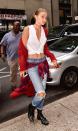 <p>The sweltering temps in NYC this weekend didn't stop Gigi from embracing fall style. The model stepped out in a fuzzy red cardigan and distressed denim with a plaid flannel tied around her waist and black leather combat boots. </p>