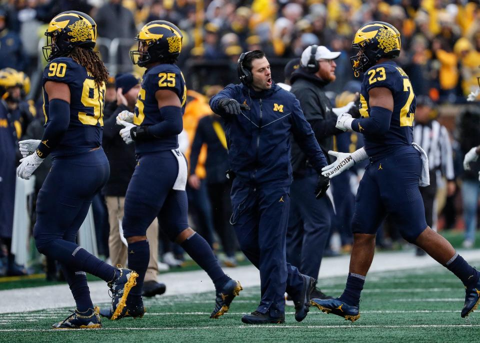 Michigan linebackers coach George Helow high-fives players after a play against Nebraska during the first half of U-M's 34-3 win over Nebraska on Saturday, Nov. 12, 2022, in Ann Arbor.