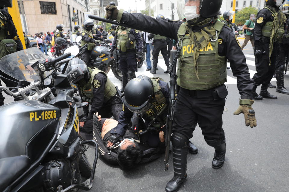 Police detain a man amid protests near Congress where lawmakers swear-in Manuel Merino, head of Peru's legislature, as the new president in Lima, Peru, Tuesday, Nov. 10, 2020. Congress voted to oust President Martin Vizcarra over his handling of the new coronavirus pandemic and unproven allegations of corruption years ago. (AP Photo/Rodrigo Abd)