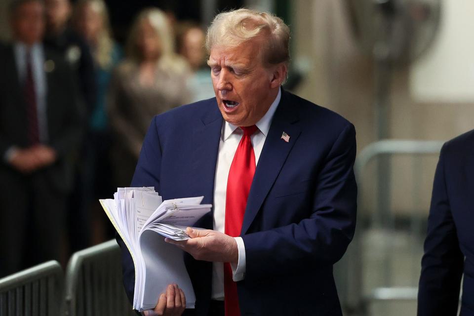 Former President Donald Trump displays a stack of papers while departing a New York City criminal court on April 23, 2024.