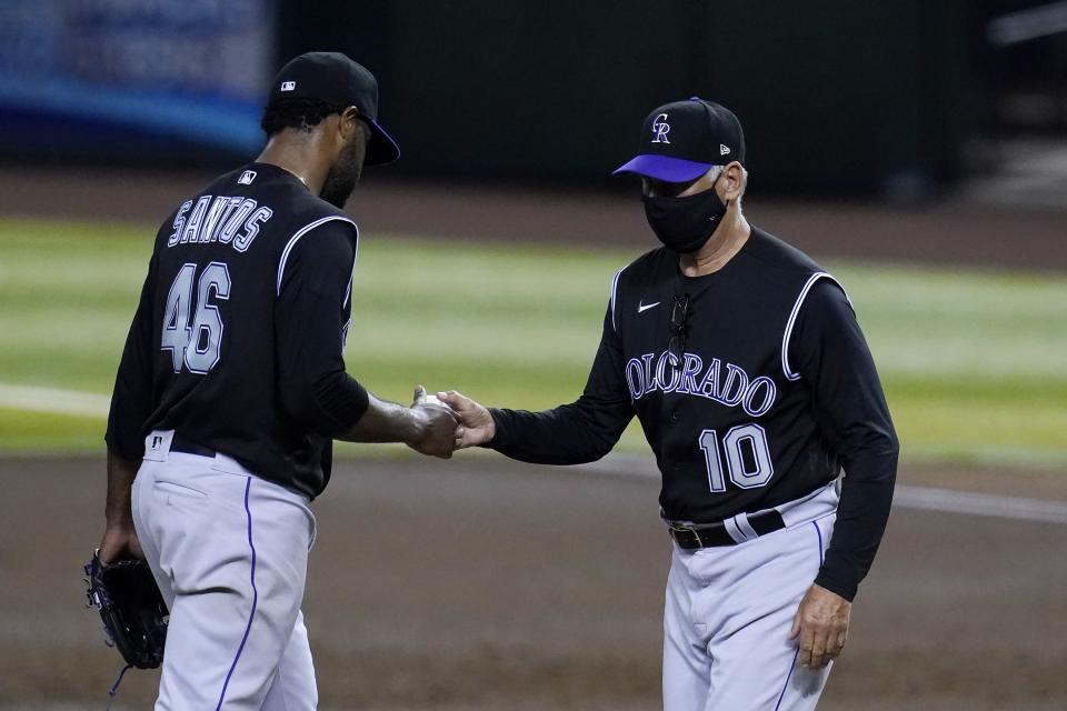 Colorado Rockies manager Bud Black (10) takes the ball from starting pitcher Antonio Santos as Santos is removed during the first inning of the second game of the team's baseball doubleheader against the Arizona Diamondbacks on Friday, Sept. 25, 2020, in Phoenix. (AP Photo/Ross D. Franklin)