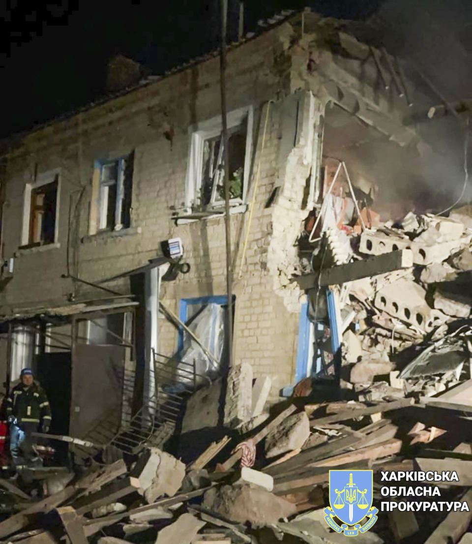 In this photo provided by Kharkiv Regional Prosecutor's Office, firefighters examine the site of Russia's missile attack that hit an apartment building in Kharkiv Region, Ukraine, Thursday, Feb. 15, 2024. (Kharkiv Regional Prosecutor's Office/ via AP)