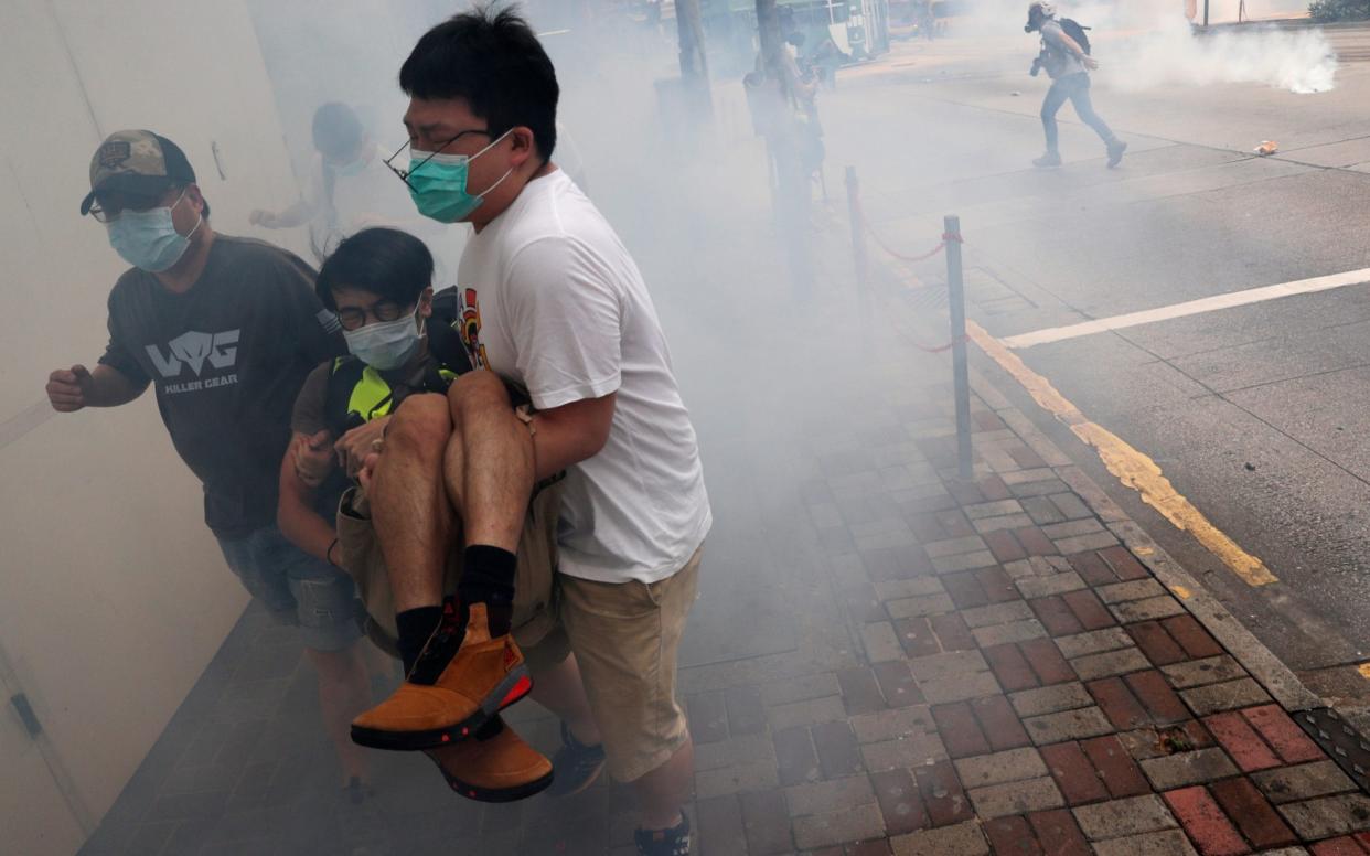 Anti-government protesters run away from tear gas during a march against plans to impose national security legislation in Hong Kong - Reuters