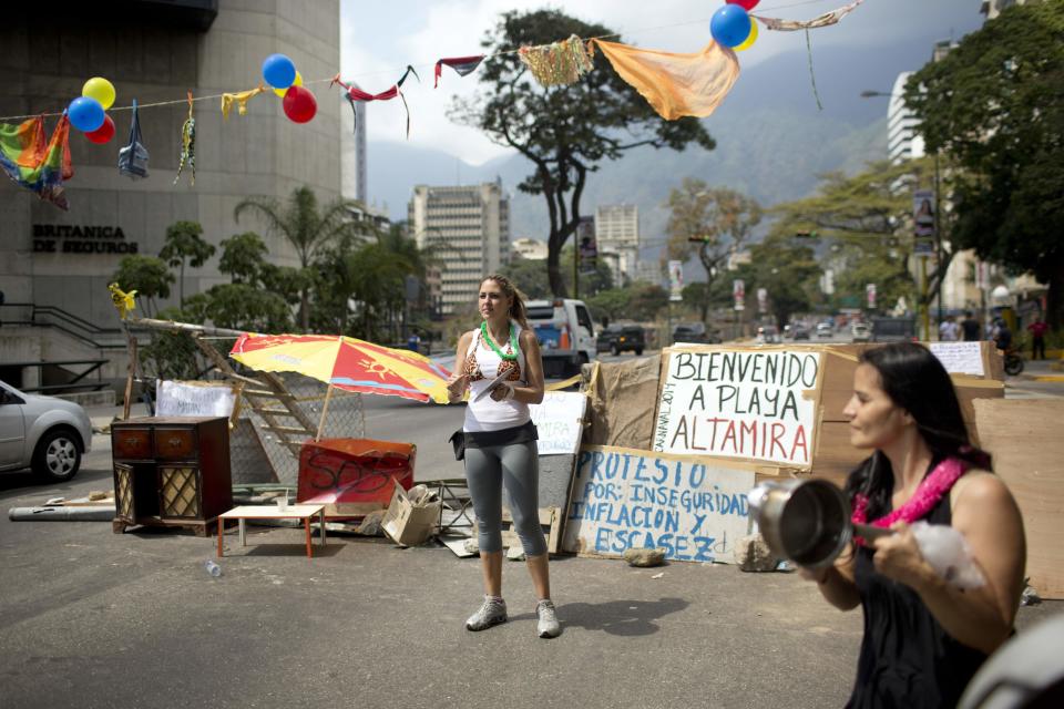 Mujeres golpean cacerolas frente a una barricada en Caracas, Venezuela, el viernes 28 de febrero de 2014. (AP foto/Rodrigo Abd)