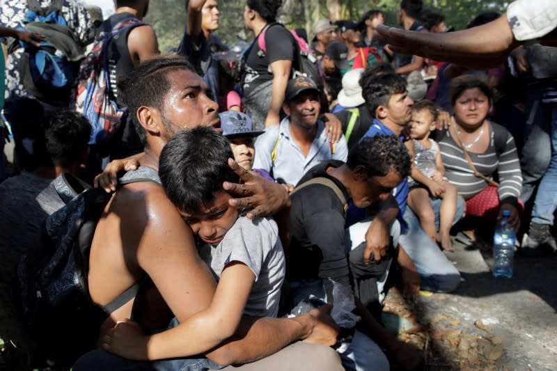 Migrants, mainly from Central America and marching in a caravan, react near Frontera Hidalgo, Chiapas