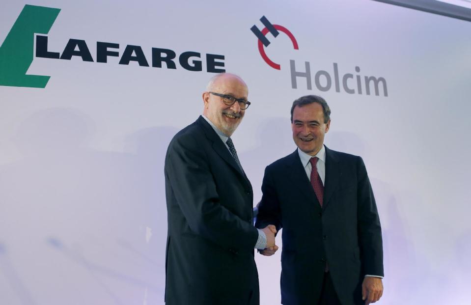 Bruno Lafont, right, chairman and chief executive of French cement maker Lafarge Group shakes hands with Swiss cement maker Holcim chairman Rolf Soiron during a press conference, Monday, April 7, 2014 in Paris. Lafont and Soiron announced plans for a "merger of equals" Monday that would create an industry giant with a combined euro32 billion (US$43.9 billion) in annual revenues. (AP Photo/Jacques Brinon)